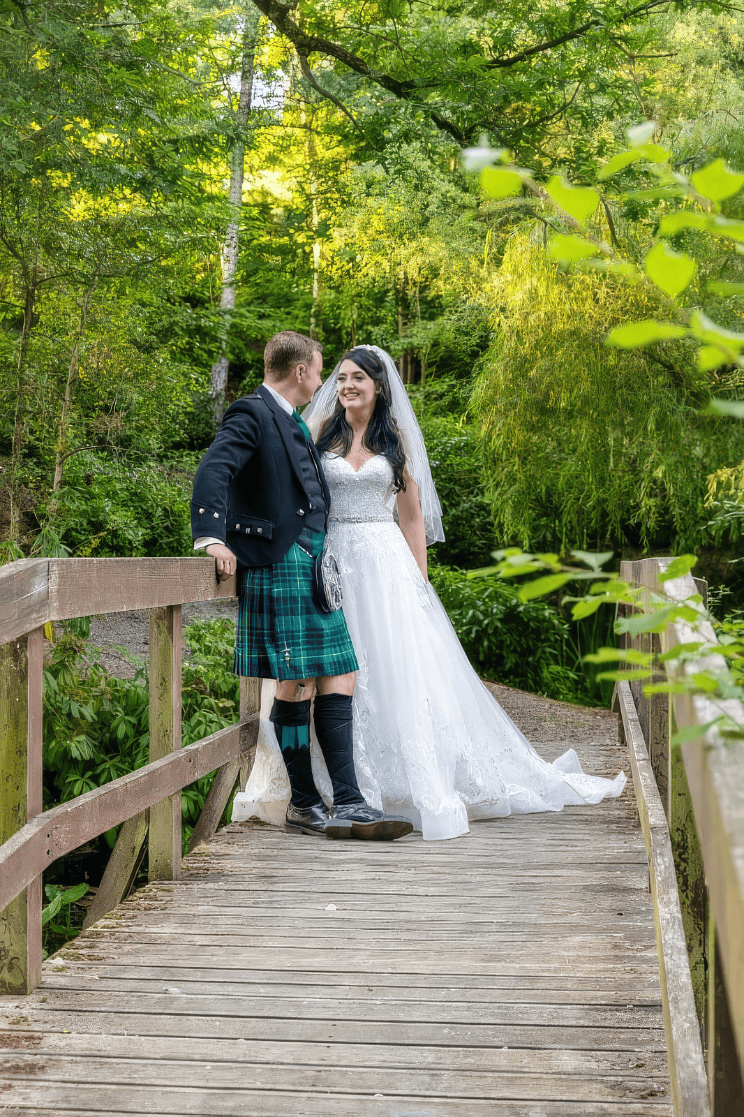 glamour-brides-claire-salomons-estate-kent-natural-bridal-makeup.jpg Bride and groom embracing on wooden bridge at Salomons Estate wedding