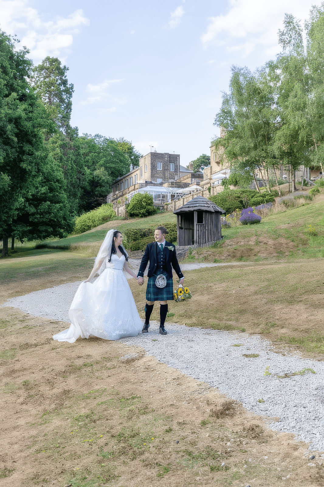 glamour-brides-claire-salomons-estate-kent-soft-glam-makeup.jpg Bride walking with flower girl along countryside path at Salomons Estate wedding